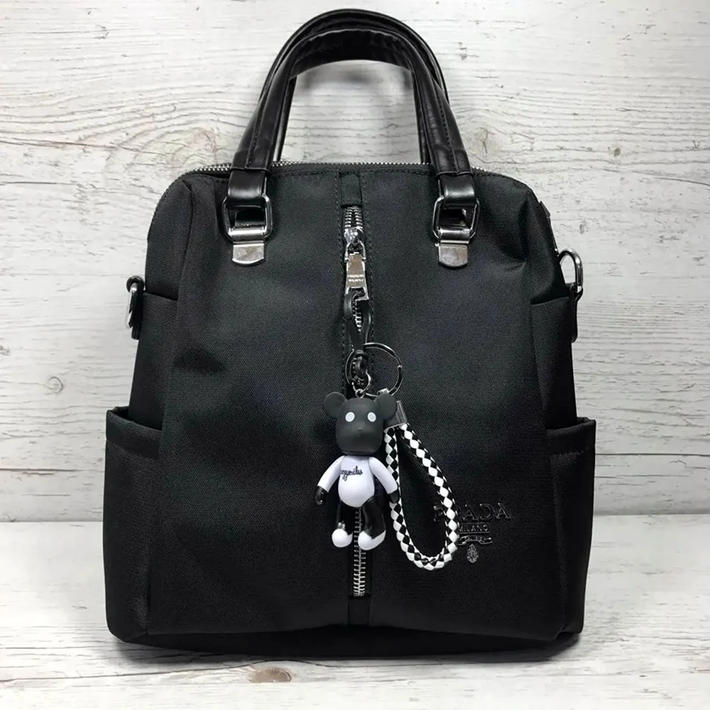 Черная сумка-рюкзак Прада с брелоком