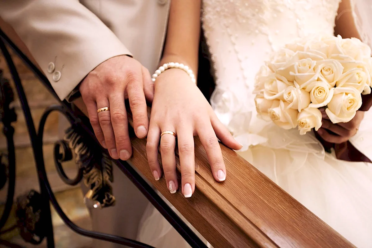 Обручальные кольца на руках жениха и невесты