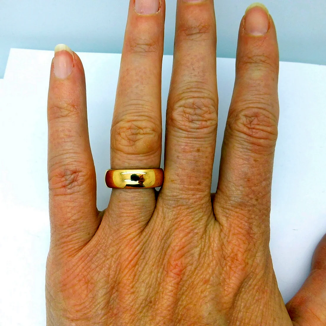 Широкое обручальное кольцо на пальце